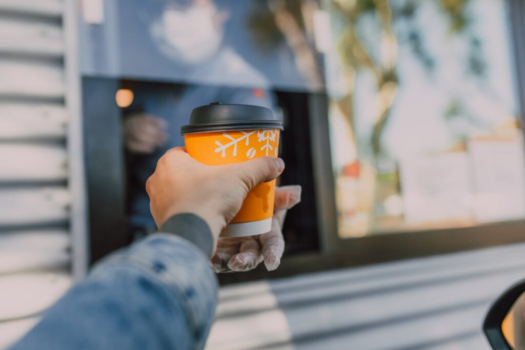 Man getting a hot coffee to go from a coffee cart